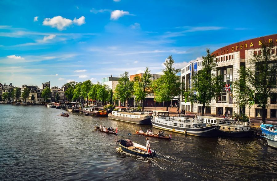 по каналу Амстердама плывут лодки, достопримечательности Амстердама